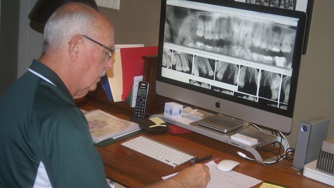 Dr. Richard Scanlon, a NamUs regional forensic odontologist, compares dental radiographs of missing and unidentified persons in hopes of securing a positive identification.