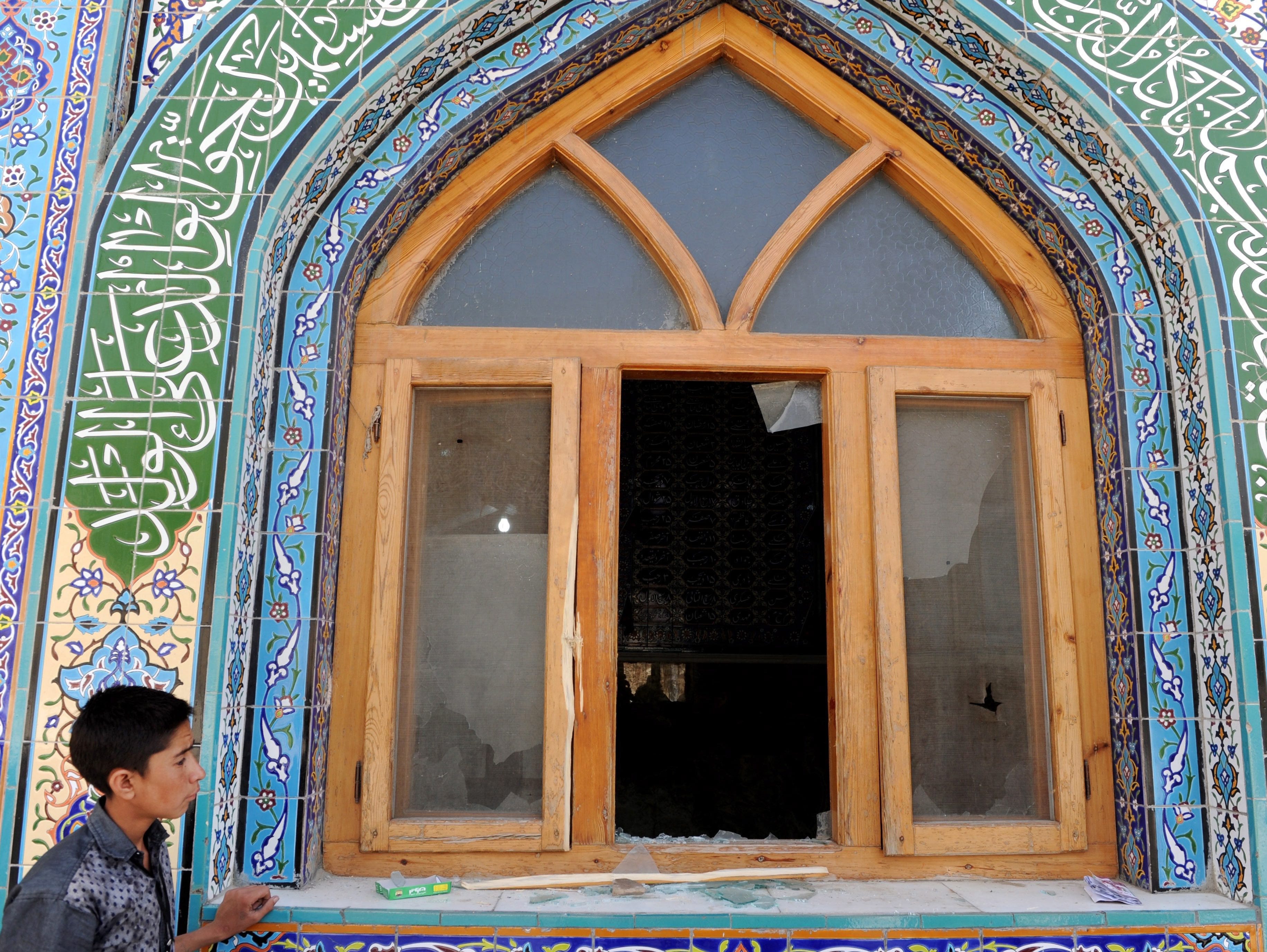 An Afghan boy surveys the site of an attack that targeted a Shiite Muslim Mosque by suspected militants, in Kabul, Afghanistan, Oct. 12, 2016.