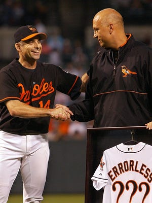 Baltimore Orioles shortstop Mike Bordick, left, shakes hands with Cal Ripken during a pregame ceremony honoring Bordick's consecutive game errorless streak prior to the start of a game against the New York Yankees at Camden Yards in Baltimore Friday, Sept. 27, 2002.  Bordick set the major league record for consecutive errorless games at shorstop.