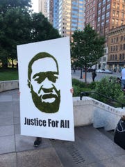 A protestor carries a poster featuring a picture of George Floyd on May 31, 2020. Floyd, a 46-year-old black man, was killed while in police custody after allegedly passing a counterfeit $20 bill at a convenience store.