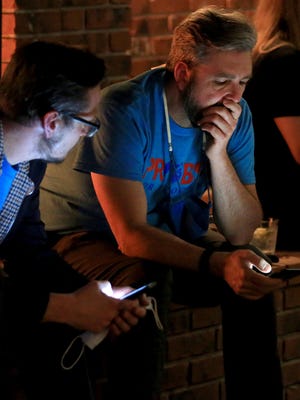 Rep. Jason Probst, D-Hutchinson, right, looks at election results on Tuesday evening at an event in Hutchinson.
