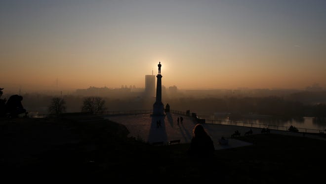 In this photo taken Friday, Dec. 9, 2016, a sunset over monument "The Victor", a distinctive symbol of Belgrade appears from Kalemegdan fortress in Belgrade, Serbia. Belgrade has emerged as one of Europe's prime party destinations.