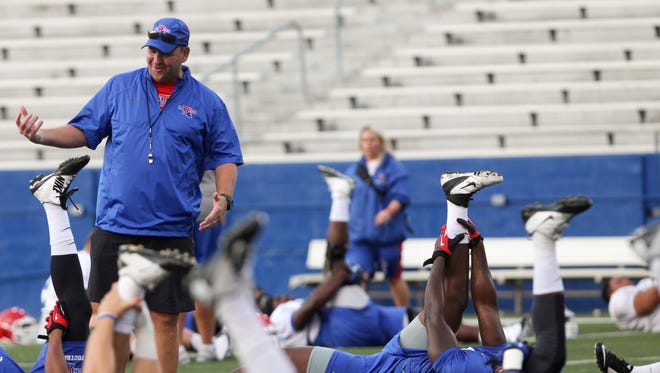 Louisiana Tech head football coach Skip Holtz talks with players as they stretch during practice Thursday at Joe Aillet Stadium in Ruston.
