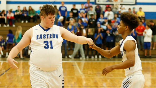 Eastern High School basketball senior manager Cory Pitsenberger fist bumps teammate Braxton Johnson as they take the floor on senior night against Atherton High. Feb. 13, 2017