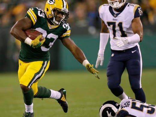 Green Bay Packers running back Aaron Jones (33) evades