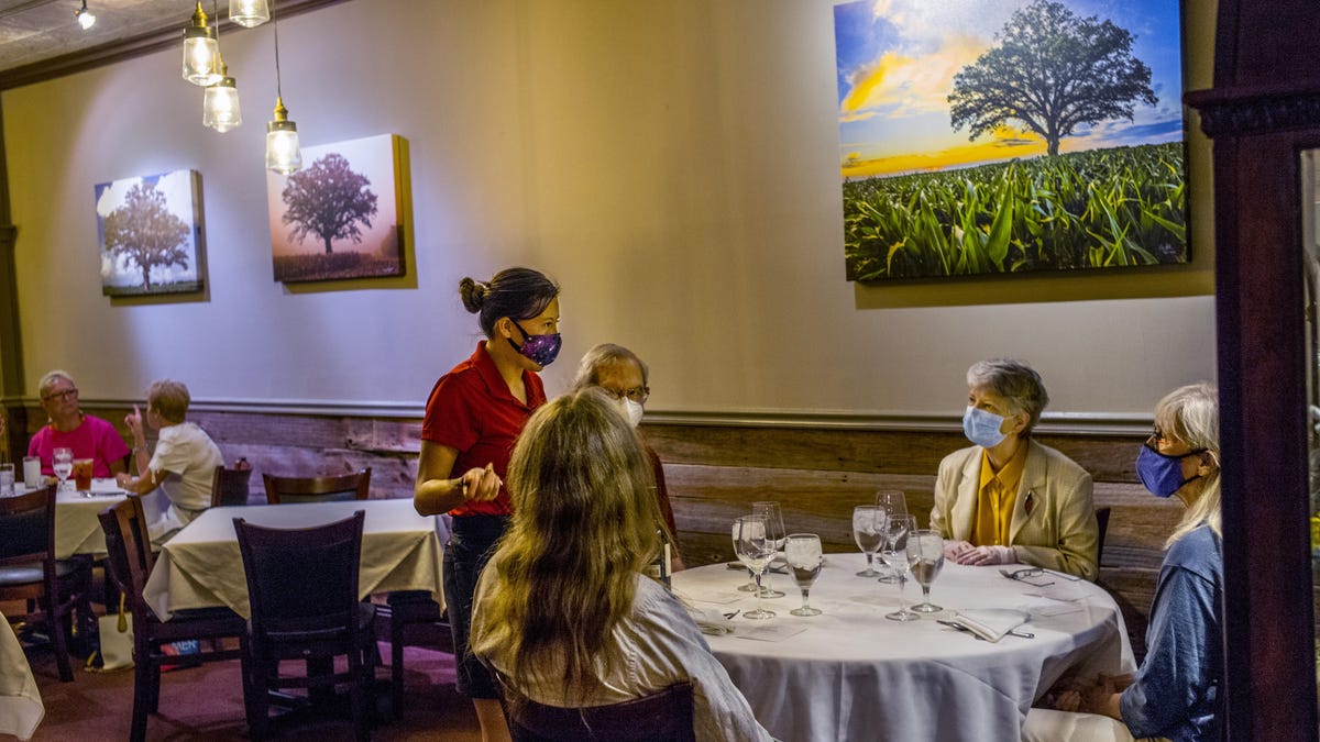 Hearth restaurant server Becky Welch talks with customers, clockwise from foreground, Doug Leunig, John and Sharon Amdall and Eileen Leunig as inside dining opens Friday, June 26, 2020 with easing of COVID-19 pandemic restrictions. When those restrictions initially eased with restrictions limiting dining to outdoors only, the Amdalls immediately made a reservation to help out. With the announcement that indoor dining would return Friday, they made a reservation for the first day of indoor service.