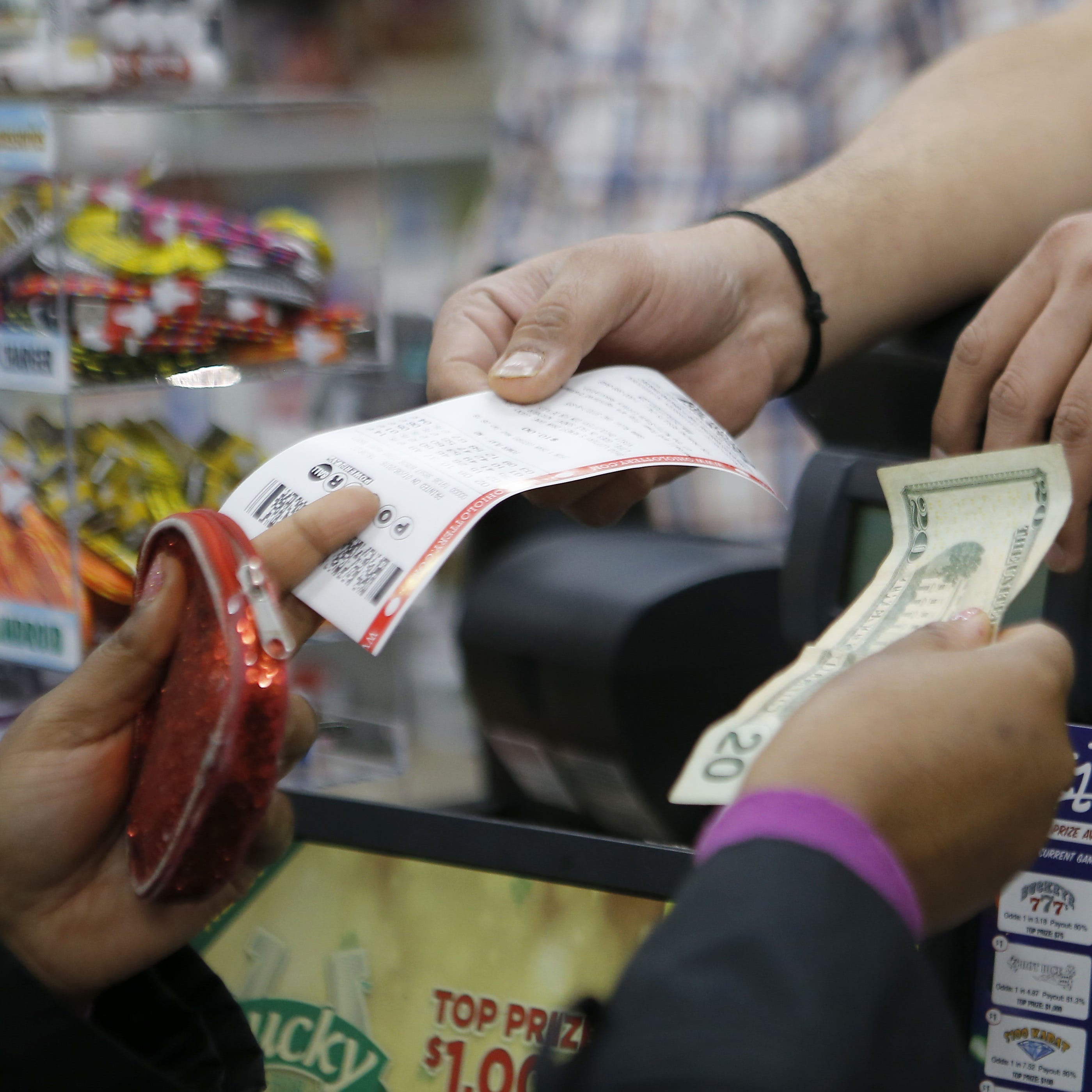 Sudhakar Gundaji sells Powerball lottery tickets at Garfield Mini-Mart in downtown Cincinnati on Wednesday, Jan. 6, 2016. Wednesday's Powerball jackpot is an estimated $700 million.