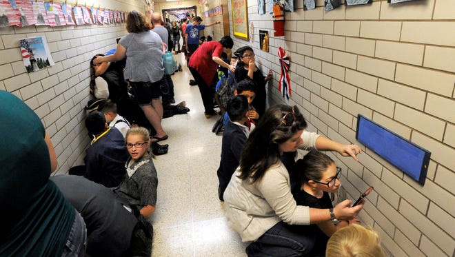 Parents, faculty and students huddle in a hallway at Dyess Elementary School Friday May 19, 2017 after a tornado warning interrupted the school's annual "I Love America" patriotic program. Once the all-clear was given, the show resumed.