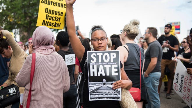 MINNEAPOLIS, MN - AUGUST 14:  A woman raises her fist at the front of a march down Washington Avenue to protest racism and the violence over the weekend in Charlottesville, Virginia on August 14, 2017 in Minneapolis, Minnesota. Protesters estimated at more than 1,000 blocked streets and light rail during the action.  (Photo by Stephen Maturen/Getty Images)