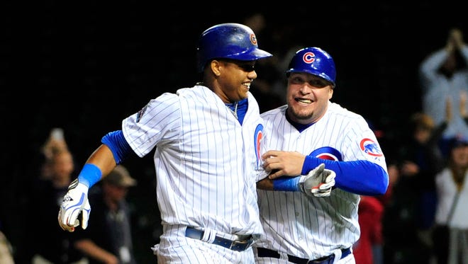 Chicago Cubs shortstop Starlin Castro (left) celebrates with coach Eric Hinske after driving in the winning run against the Colorado Rockies in the sixteenth inning at Wrigley Field.
