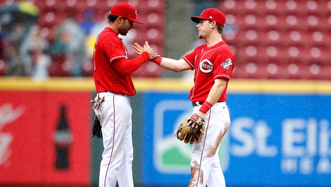 The Reds José Peraza, left, and Scooter Gennett celebrate their 4-2 win over the Pirates.