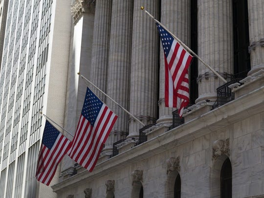Front of New York Stock Exchange, with flags hanging from top of columns.