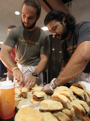 Rusted Rooster employees prepare buttermilk biscuit, fried chicken and pepper jelly sliders in this Advertiser file photo.