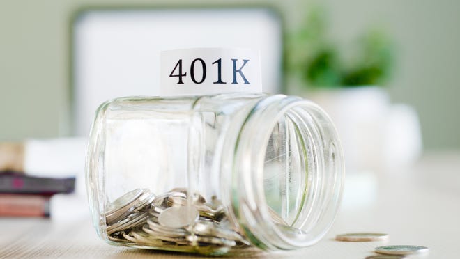 Tipped over glass jar full of coins that's labeled 401(k)