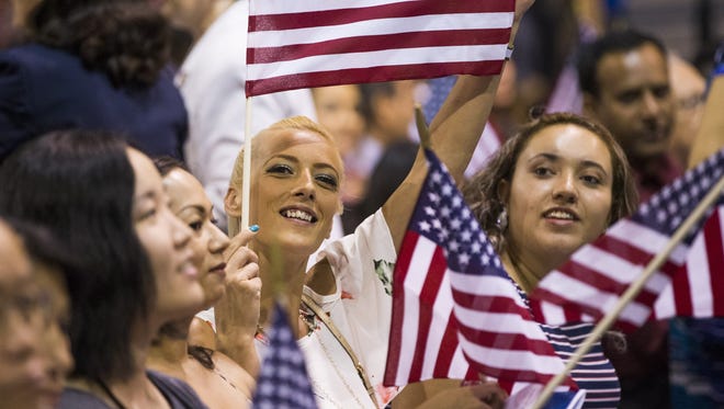 Enisa Delic from Bosnia proudly holds a flag during a naturalization ceremony at South Mountain Community College in Phoenix, Arizona on Tuesday, July 4, 2017. 151 people from 43 countries were sworn in as citizens.