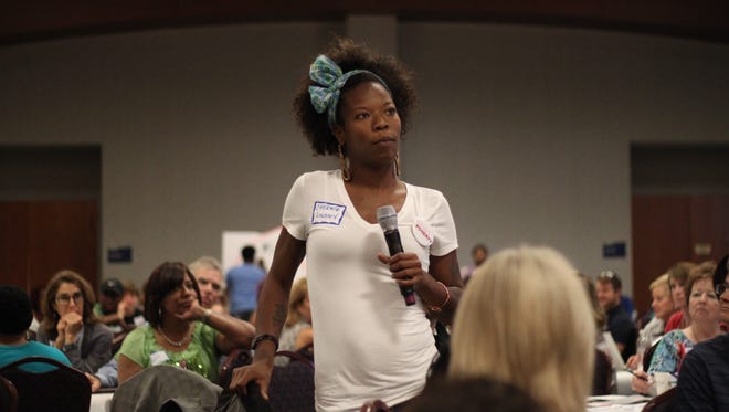 Cheriere Lindsey, who works in construction, speaks to the crowd after a table discussion at the Child Poverty Collaborative summit.