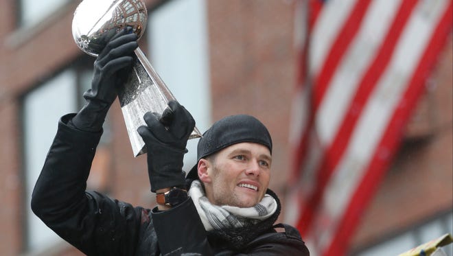 Tom Brady raises the Vince Lombardi Trophy during the Super Bowl LI champions' parade through downtown Boston on Tuesday.