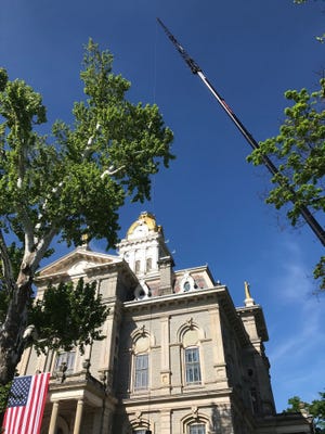 A crane rises above the Licking County Courthouse as Robertson Construction works to place an American flag on top of the dome.
