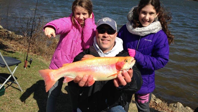 Capt. Jeff DeMuro of Insufishent Funds Fishing holds a golden trout caught by Asha Gupta, 11, (right) and her sister, Abby, 8, of Allenwood at last year's Kids Trout Contest.