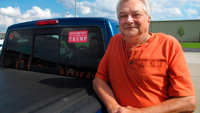 Bob Schrameyer stands next to his truck decorated with a "Build The Wall - Vote Trump" sticker in Goshen, Ind., on Thursday, May 31, 2018. A decade ago, Schrameyer and fellow Goshen residents lobbied police to partner with ICE, and pushed employers to vet workers’ legal status. The problem, Schrameyer contends, is that many immigrants don’t pay their fair share of taxes, while collecting welfare benefits.