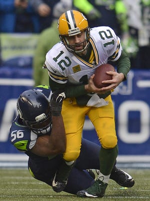 Green Bay Packers quarterback Aaron Rodgers (12) is sacked by Seattle Seahawks defensive end Cliff Avril (56) in the third quarter during Sunday's NFC Championship game at CenturyLink Field in Seattle, Wash.