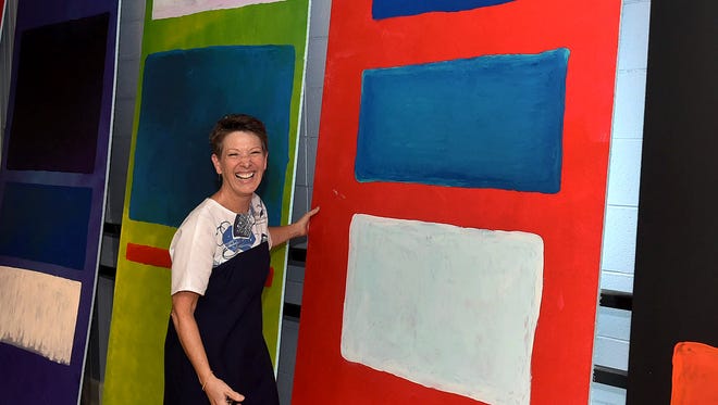 Cindy Pitre displays student-created art waiting for display in empty storefronts in downtown Opelousas.