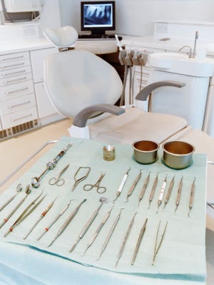 Dentist chair and dental tools on a trolley.