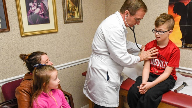 Dr. James Buckmaster examines Merick White, 11 years-old, while his mother Nicole White and sister Dallas White, 6 years-old, look on in his Corpus Christi Clinic office on Barrett Blvd Wednesday. Construction will start soon on a new Corpus Christi Clinic to be located a the corner of Green and Second Streets in Henderson, February 1, 2017.