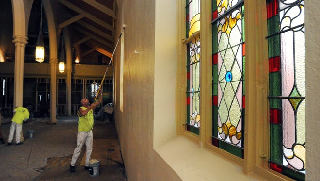 A Brian Bros. Painting and Restoration crew paints the interior walls of the church Thursday at St. Mary's Church.