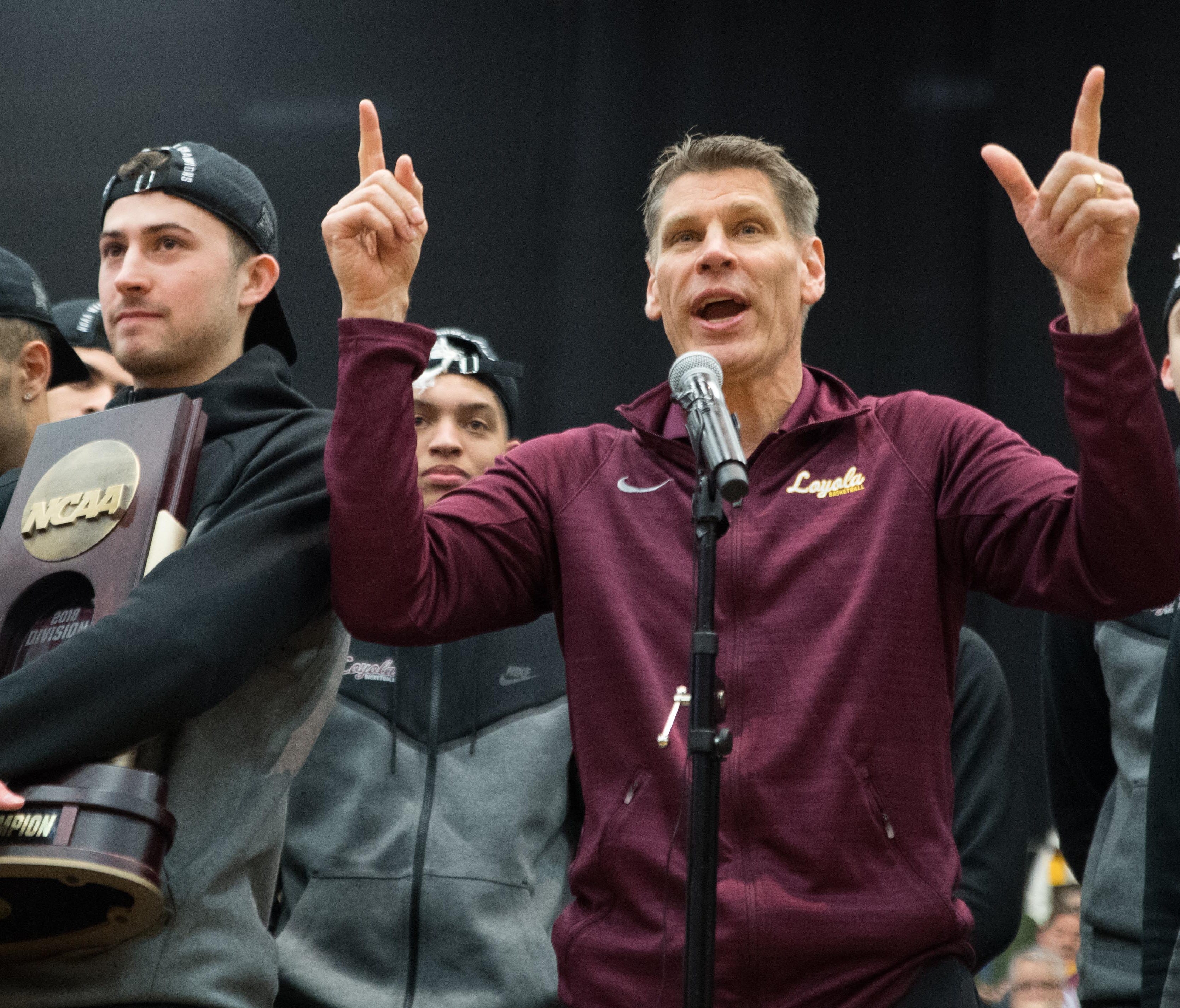 Loyola Ramblers head coach Porter Moser (right) speaks to fans as guard Ben Richardson holds the NCAA South Regional Championship trophy they celebrate reaching the Final Four with fans.