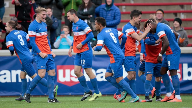 FC Cincinnati forward Sean Okoli (9), far right, is congratulated after scoring the first goal of the game on a scissor kick in the first half during the USL soccer game between the Charlotte Independence (1-1-0) and FC Cincinnati (1-1-0), Saturday, April 9, 2016, at Nippert Stadium in Cincinnati. 