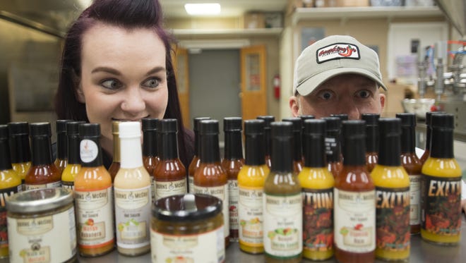 Michelle and Jay Turner pose for a portrait with their line of Burns and McCoy hot sauce. The company has been making the sauces for over a year.