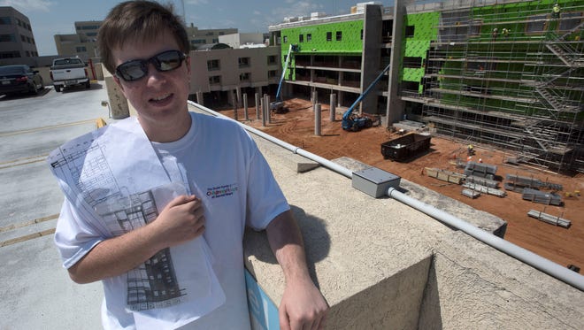 Joshua Wilhelm checks on the progress of construction of The Studer Family Children’s Hospital at Sacred Heart, Thursday, April 19, 2018. Wilhelm, who is on the Autism-spectrum, has spent months monitoring the construction project from the parking garage overlooking the building site.  