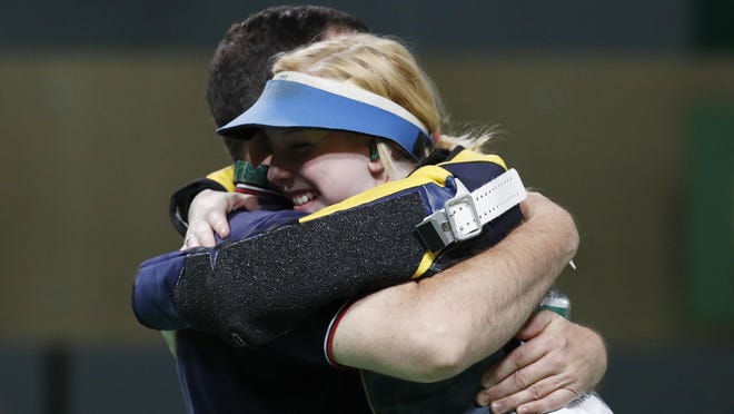 Virginia Thrasher of the United States celebrates with her coach after winning the gold medal for women’s 10m air rifle on Saturday. It was the first medal awarded at the 2016 Rio Games.