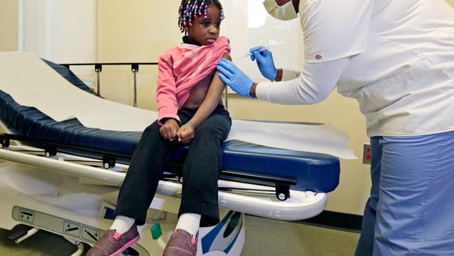 Registered nurse Charlene Luxcin gives Gabriella Diaz, 4, a flu shot last January at the Whittier Street Health Center in Boston, Mass. The Centers for Disease Control and Prevention on Monday, Jan. 5, 2014, reported flu season is getting worse.
