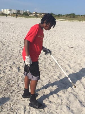 Jaden Johnson, 11, of Maryland’s Finest AAU basketball team, helps clean the beach near Lori Wilson Park in Cocoa Beach.