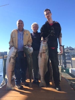 Ron an Pat Johnston with her grandson Kyle Place, all of Manasquan, hold their striped bass catch.