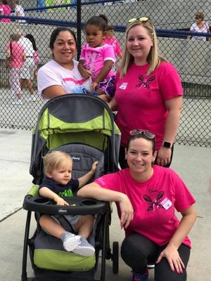 From left, customer service representatives Antonia Lezama, Megan Crews and Dana Brown and their family members slow down for just a minute at the 2017 American Cancer Society’s Making Strides Against Breast Cancer Walk.