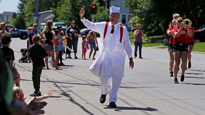John Steltz as "Hamburger Charlie" waves to the crowd during the Burger Fest parade Saturday in Seymour.