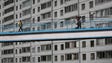 North Koreans walk past a residential building as they