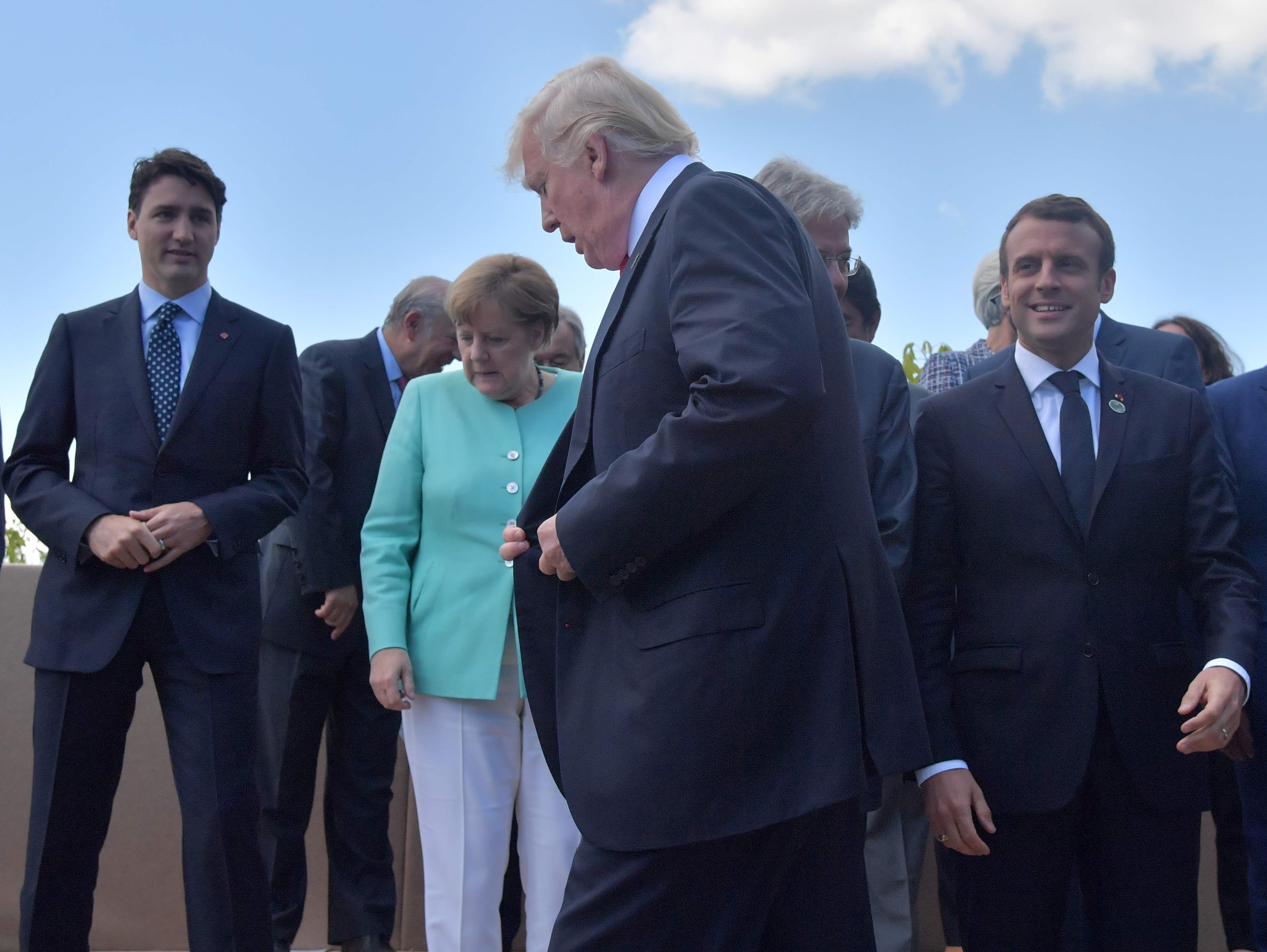 President Trump walks past Canadian Prime Minister Justin Trudeau, German Chancellor Angela Merkel, French President Emmanuel Macron and Niger's President Mahamadou Issoufou at a 