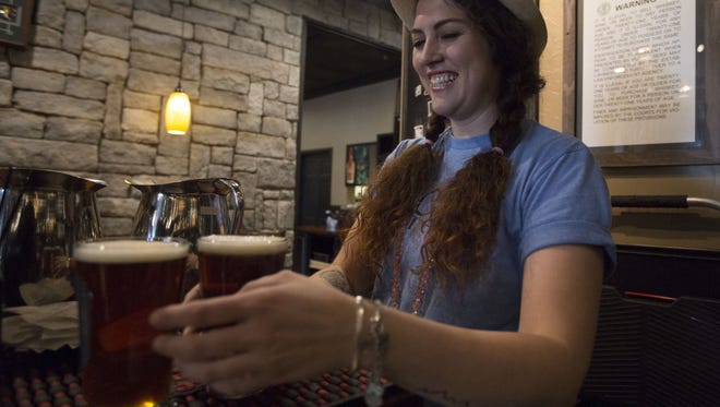 Elise Zahtila takes drinks to a table at William Oliver's Publick House.