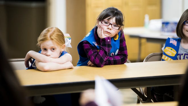 Cadence Kennely, 7, left, and Alyssa Poole, 6, wait patiently as a book is passed around during a Girl Scout meeting at St. Paul's United Church of Christ Tuesday. The book, "The Too Small Elephant," was written by Christine Callahan and is focused on how to deal with bullies.