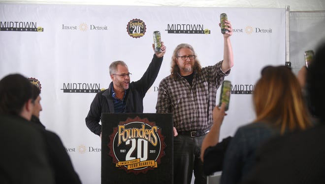 Mike Stevens, left, and Dave Engbers of Founders Brewing, raise their beers as they are welcomed to Detroit during a press conference to announce a new taproom on Tuesday April 25,  2017.