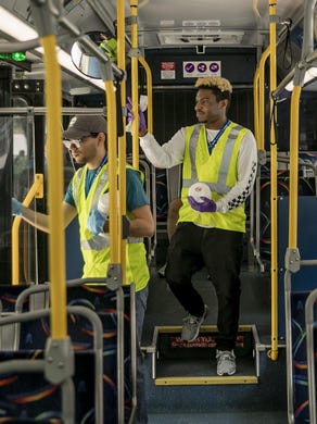 Freddy Rodriguez, left, and Aaron Jones clean a Capital Metro bus at the Republic Square station on March 26 amid the coronavirus pandemic. Buses that pull into the station are getting cleaned with disinfecting wipes.