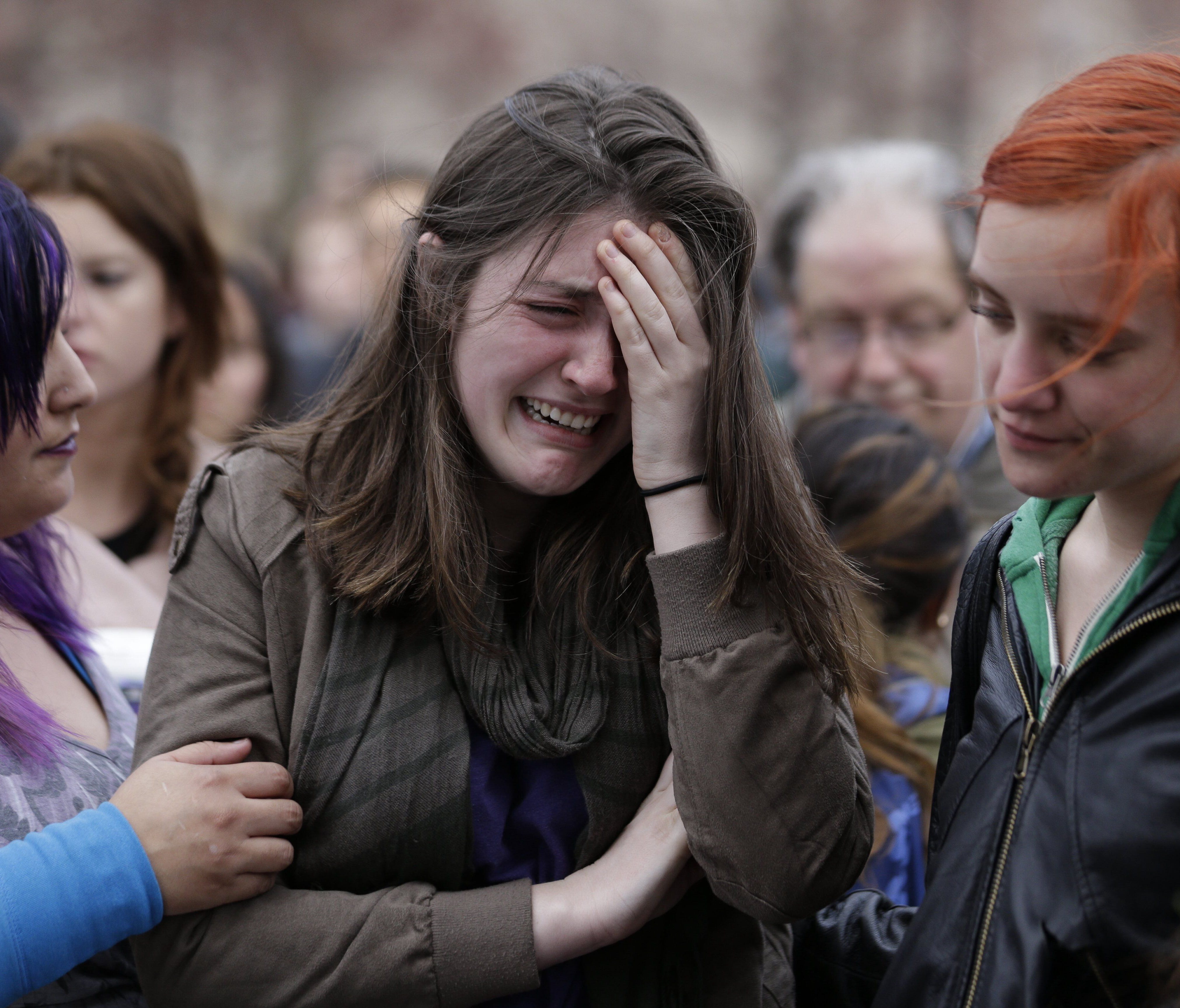 Emma MacDonald, 21, center, cries during a vigil for the victims of the Boston Marathon explosions at Boston Common, Tuesday, April 16, 2013.