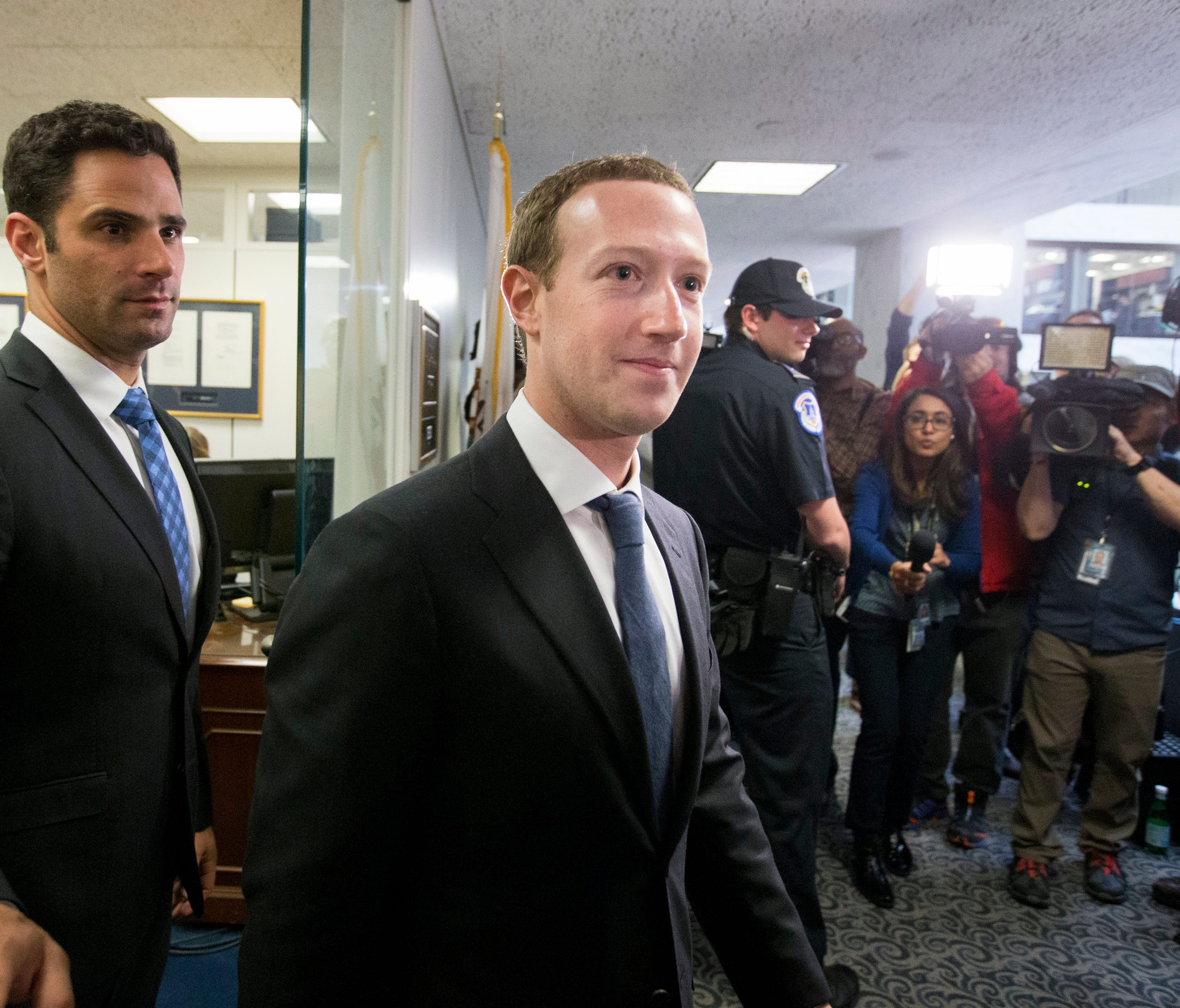 Facebook CEO Mark Zuckerberg (center) walks out of Sen. Dianne Feinstein's office after their meeting on Capitol Hill.