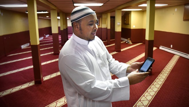 Imam Mohamed Nuh Dahir of the the Islamic Center of St. Cloud demonstrates an app he uses to read the Quran on his smartphone.
