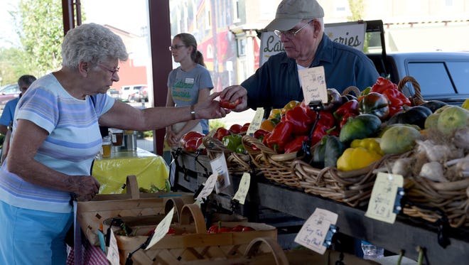 photos by Sara C. Tobias/The Advocate
Carol King buys tomatoes from Tom Bird of Bird's Haven Farms on Tuesday at the Canal Market District.
Carol King buys tomatoes from Tom Bird of Bird's Haven Farms during the Canal Market District on Tuesday, Aug. 24, 2016.