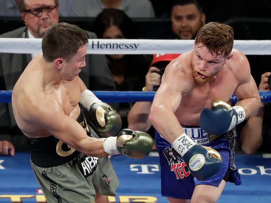 Canelo Alvarez, right, follows through on a right to Gennady Golovkin during a middleweight boxing bout Saturday, Sept. 16, 2017, in Las Vegas. (AP Photo/Isaac Brekken)